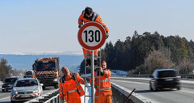 Straßenwärter Tobias Schäuble montiert an der A81 am Hegaublick das Schild mit dem Tempolimit 130.