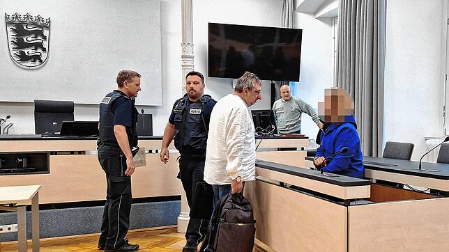 Der Angeklagte wird von den Wachtmeistern in den Gerichtssaal gebracht. Hier spricht er mit seinem Verteidiger Uwe Runge.