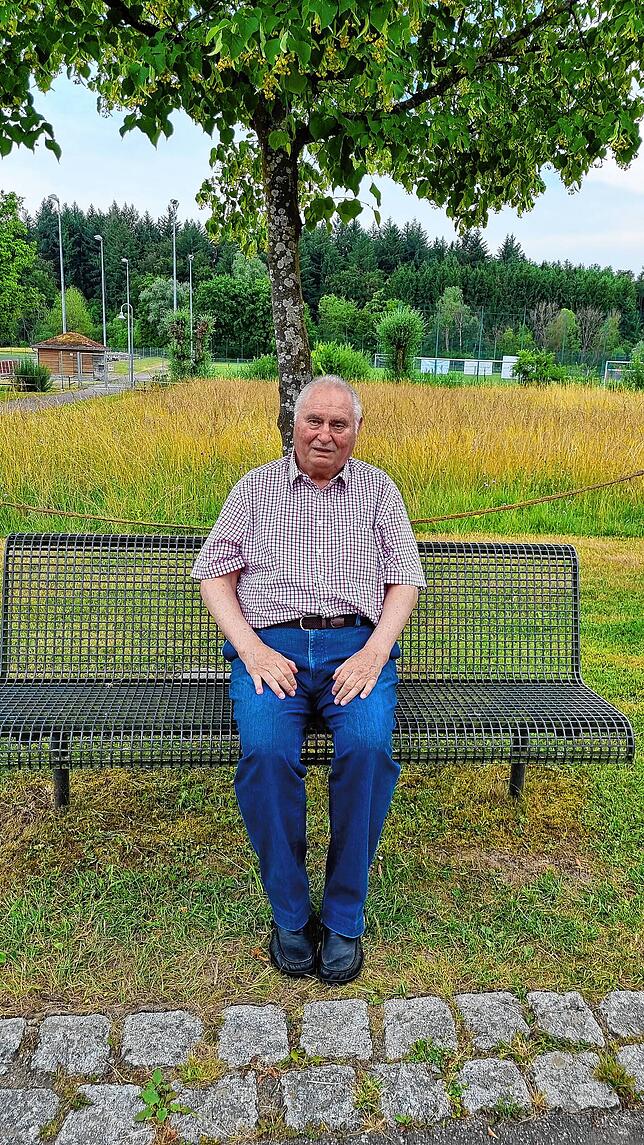 Turnier-Organisator Manfred Lüttin auf der Bank vor der Riesenberghalle.