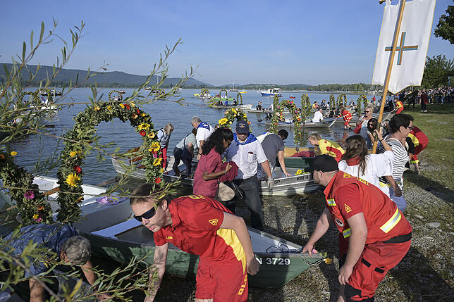 DLRG-Mitglieder helfen den Mooser Pilgern beim Anlanden am Radolfzeller Ufer.