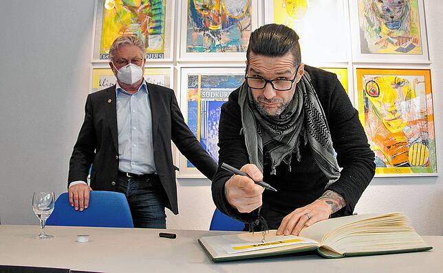 Daniel Löble darf sich in das Goldene Buch der Nachsorgeklinik Tannheim eintragen.