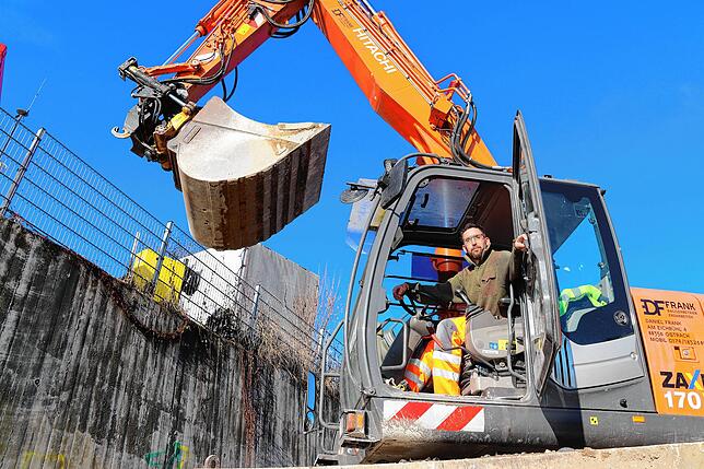 Daniel Flank ist Baggerfahrer auf der Baustelle. Aktuell rollt er in seinem Gefährt vor allem durch den Matsch.