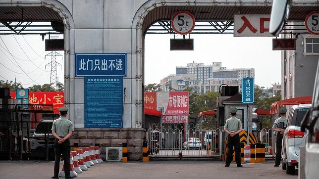 Polizisten halten vor den barrikadierten Eingängen des Xinfadi-Großmarktes Wache. Auf einem Großmarkt der chinesischen Hauptstadt wurden ...