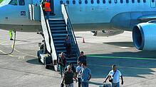 Passagiere verlassen ein Flugzeug auf dem Häfler Rollfeld.