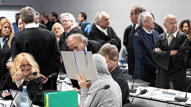 Prozessauftakt in Frankfurt gegen mutmaßliche Reichsbürger: Johanna Findeisen verbirgt Gesicht und Kopf hinter einer Mappe und unter ...