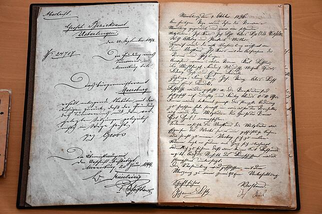 Seiten aus einem historischen Protokollbuch des TuS Meersburg. Links eine Abschrift der Anerkennung als Verein durch das ...