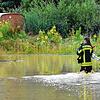 Eine Feuerwehrfrau watet durch Wassermassen in Markdorf.