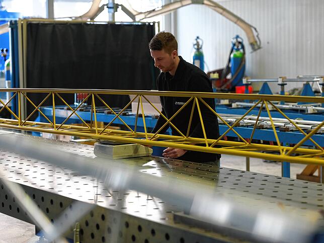 Kevin Heilig kontrolliert das Gewicht des Bauteils.