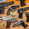 Pistolen, Revolver und Munition liegen auf einem Tisch in einer gesicherten Asservatenkammer (Symbolbild). In mehreren Verstecken ...