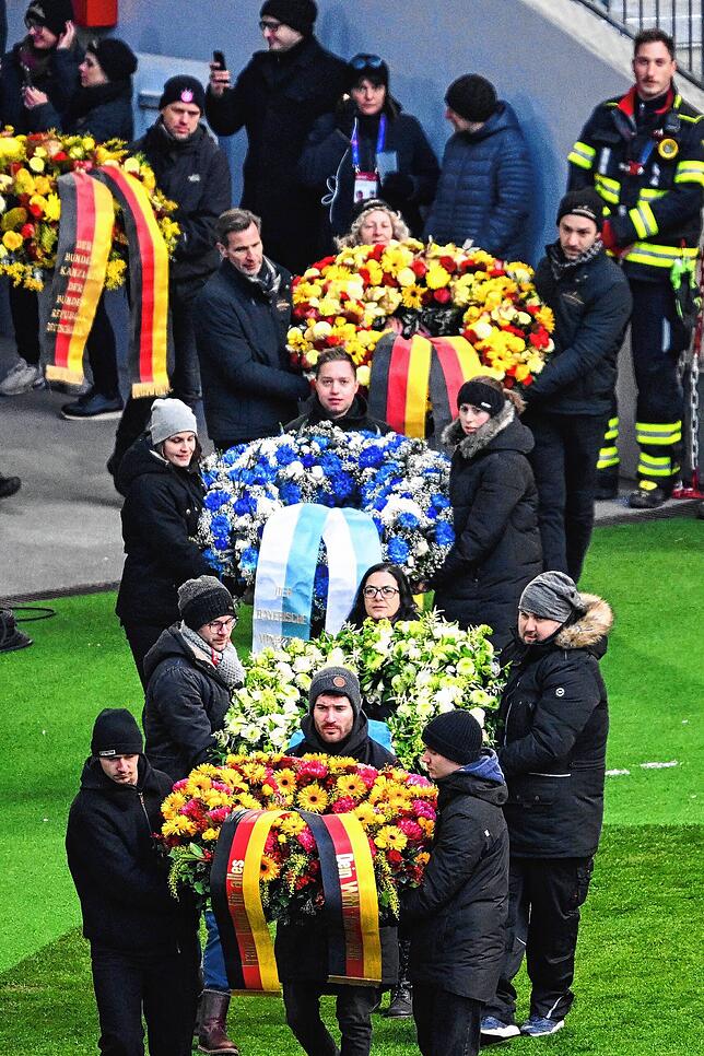Trauerkränze werden ins Stadion getragen.