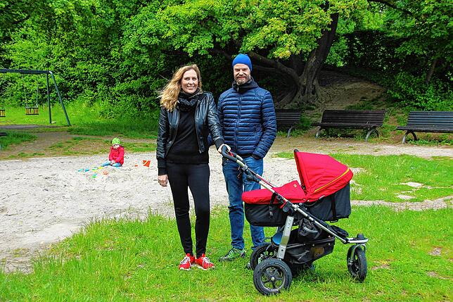 Julia und Thies Johannsen auf dem Spielplatz am Hörnle. Im Hintergrund spielt Karlo im Sandkasten, Tonio schläft im Kinderwagen.