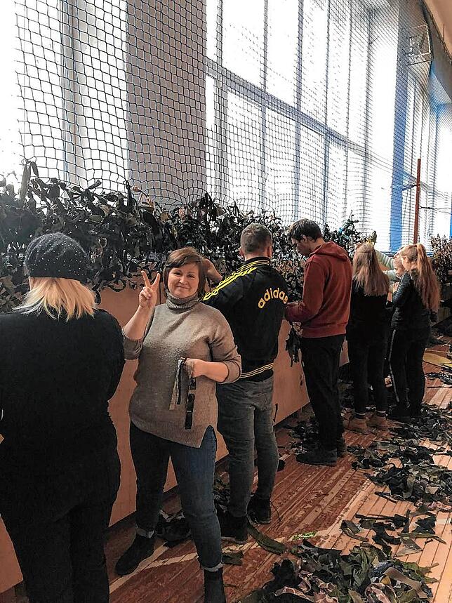 In einer Turnhalle in Kiew knüpfen Zivilisten zum Schutz vor den russischen Angriffen Tarnnetze. Auch dieses Bild erreichte Nataliya ...