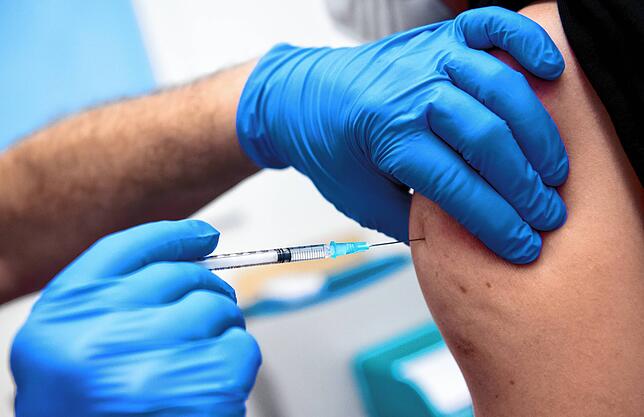 Ein Mitarbeiter der Asklepios Klinik wird von einem Kollegen mit dem Corona-Impfstoff von Biontech/Pfizer geimpft. Das Bild stammt vom ...