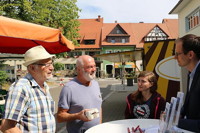 Auch Hermann Scherer und Reiner Haller nutzen den Einkauf auf dem Wochenmarkt für ein Gespräch mit Bürgermeister Bächle und Michelle ...