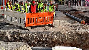 Baustellenbesichtigung in der Adolf-Müller-Straße: Eine kleine Gruppe interessiert sich für die Arbeiten. Foto: Winckelmann
