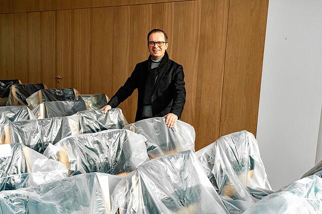 IHK-Hauptgeschäftsführer Thomas Albiez inspiziert die neuen Stühle für den großen Sitzungssaal.