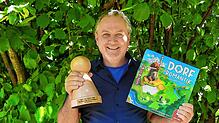 Spieleerfinder Michael Palm mit dem &bdquo;Pöppel&ldquo; für das beste Spiel des Jahres: &bdquo;Dorfromantik&ldquo;. Zusammen mit Lukas ...