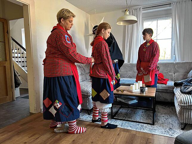 Nach dem Frühstück heißt es Häs anziehen. Mama Nadine hilft Lia beim Binden der Schürze.