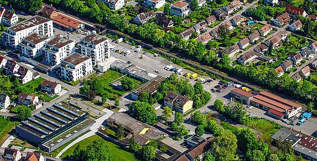 Rechts neben der Neuen Ortsmitte und oberhalb der Sporthalle werden vier weitere Wohnhäuser gebaut. Der Gebäudekomplex mit den roten ...