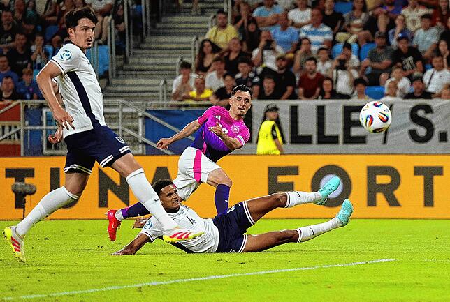 Deutschlands Paul Nebel (M) schießt gegen Englands Spieler Tino Livramento (l) und Jarell Quansah (unten) auf das Tor.