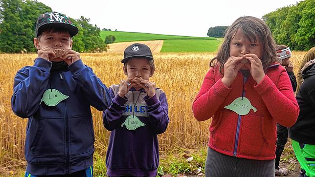 Kräftig pusten, das müssen hier Lio, Tiago und Violetta. Denn dann entsteht auf der anderen Seite der Baumscheibe Schaum.