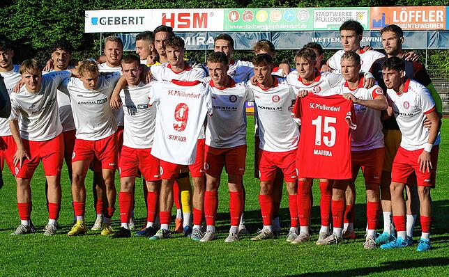 Die Pfullendorfer Mannschaft zeigt die Trikots der Verletzen Marco Straub (9) und Amadou Marena (15) vor dem Pokalspiel gegen den ESV ...