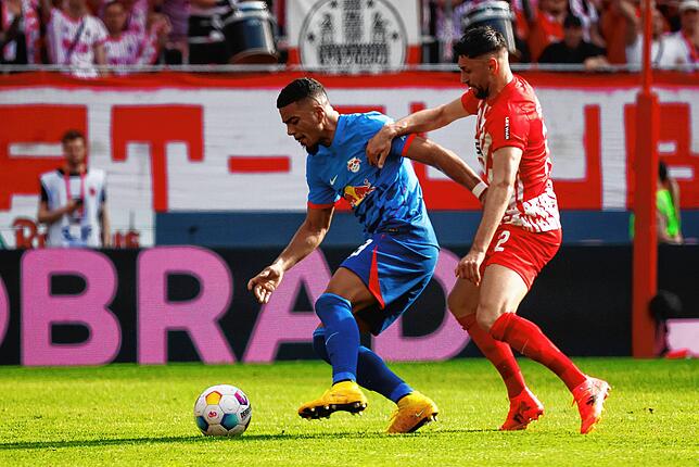 Leipzigs Benjamin Henrichs (l) und Freiburgs Vincenzo Grifo (r) im Zweikampf.