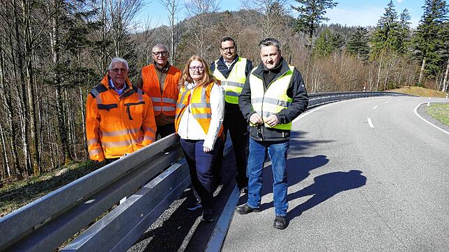 Bruno Hilbert, Reinhold Malassa, Kathrin Mies und Gerd Woop und Henrik Selisky neben dem neuen Unterfahrschutz an der Leitplanke entlang ...