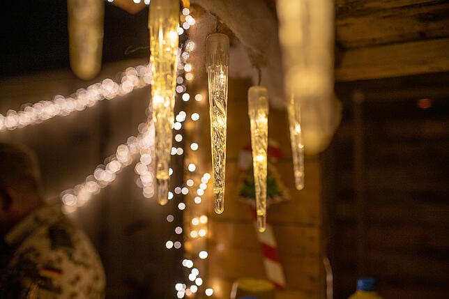 Beim Weihnachtsmarkt sorgen Lichter und Weihnachtsdeko für festliche Atmosphäre.