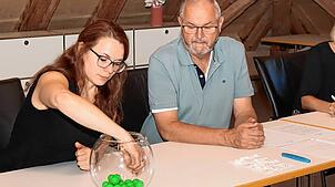 Rechnungsamtsleiterin Nicole Dold zieht also Losfee die Nummern für die Grundstücksvergabe. Bürgermeister Rudolf Fluck beobachtet das ...