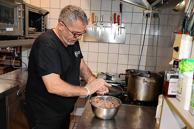 Salvatore Tancredi in der Küche des Ackerloch Grillschopfs beim Herstellen von Polpette. Die Hackbällchen werden zunächst angebraten und ...