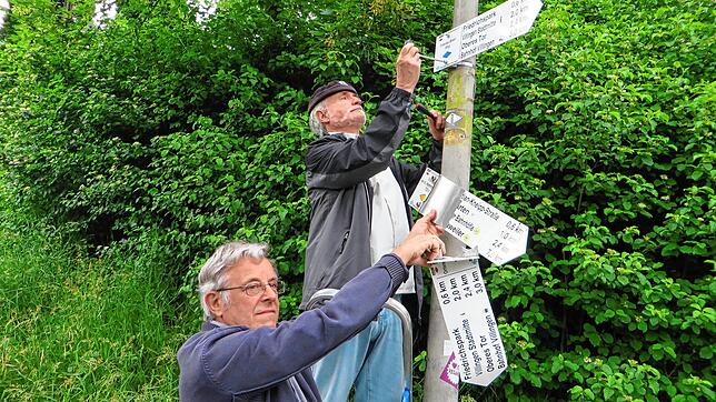 Wegewart Robert Daum und Wegewarthelfer Michael Müller ersetzen die beschädigten Schilder.