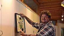 Tom Thiedmann beim Aufhängen seiner Bilder. Das Schwarzwaldmädel ist eines der wenigen größeren Bilder. Bild: Christiane Sahli