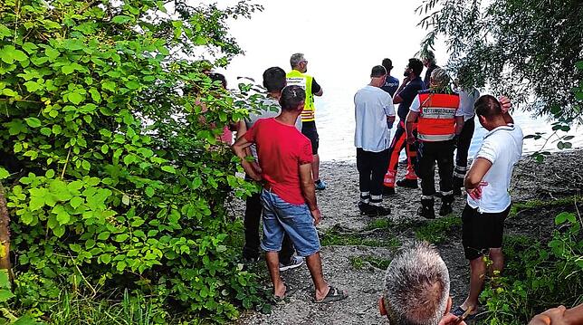 Einsatzkräfte und Kollegen des Verschwundenen beobachten am Ufer die Bemühungen.