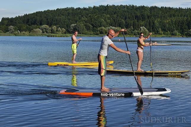 Andreas Meyer-König (Mitte) beim Stand-up-Paddeln auf dem Krauchenwieser See beim Strandbad mit Karsten Rohrbeck (links) und Yvonne Kühl.