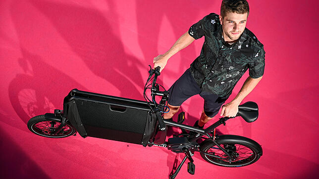 Model Julian am e-mulit Steps. Das Cargo-Bike mit faltbarem Korb wird von muli-cycles hergestellt.