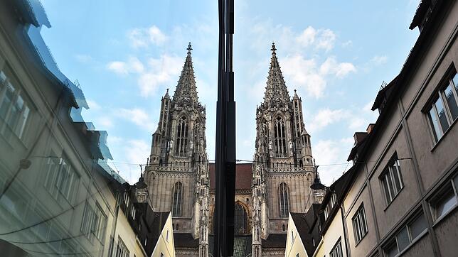 Das Münster von Ulm spiegelt sich in einer Fensterscheibe wider. In der Stadt soll eine 14-Jährige auf ihre späteren Vergewaltiger ...