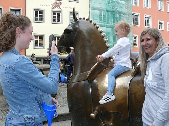 Leonie (links) fotografiert ihre Schwester Lana (2 Jahre) auf dem Pferd, rechts ihre Mutter Nicole