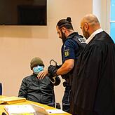 Der Angeklagte, der den Saal zu Beginn immer mit Mütze und Mundschutz betritt, wird von Waldemar Efimow (rechts) vertreten.