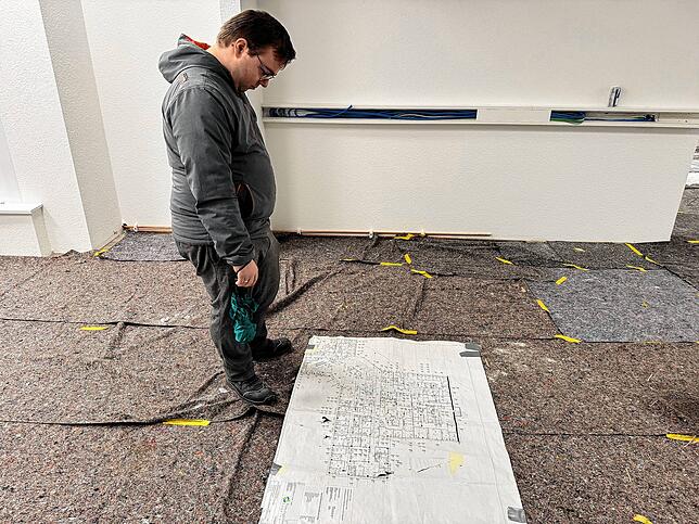 Fabio Jenisch vor einem Bauplan.
