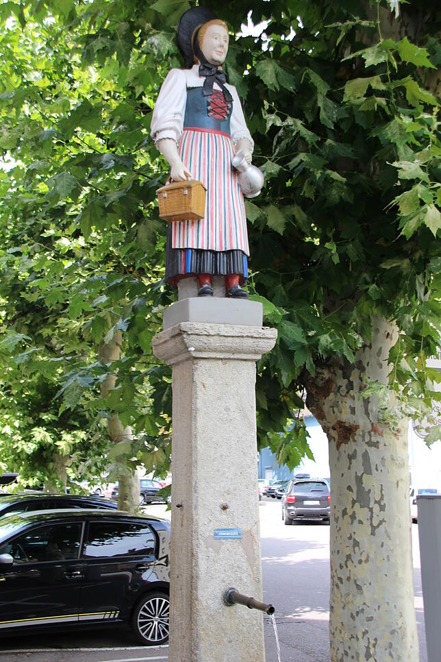 Auf dem Brunnen am Tiengener Marktplatz steht eine Figur, die eine Klettgauer Heimattracht trägt.