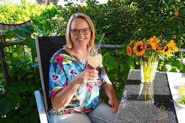 Annette Wittenberg genießt ihre hausgemachte Rhabarber-Limonade im Garten.