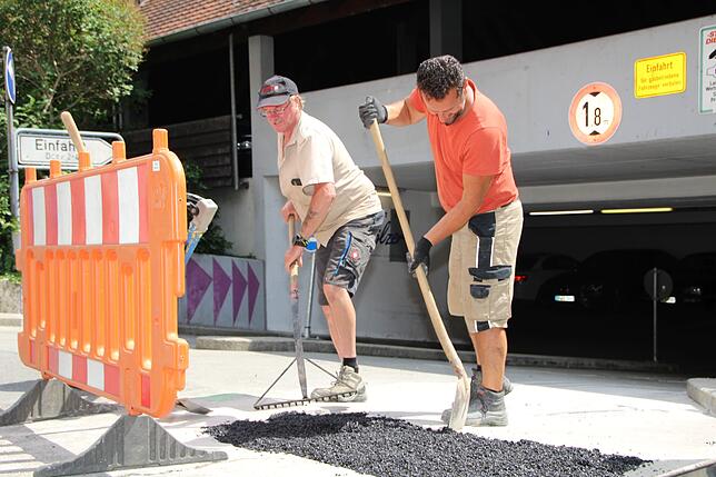 Vor dem Parkhaus Poststraße verteilen Richard Walny (links) und Mark Laski Asphalt auf einer zuvor geöffneten Stelle. Der Asphalt wird ...