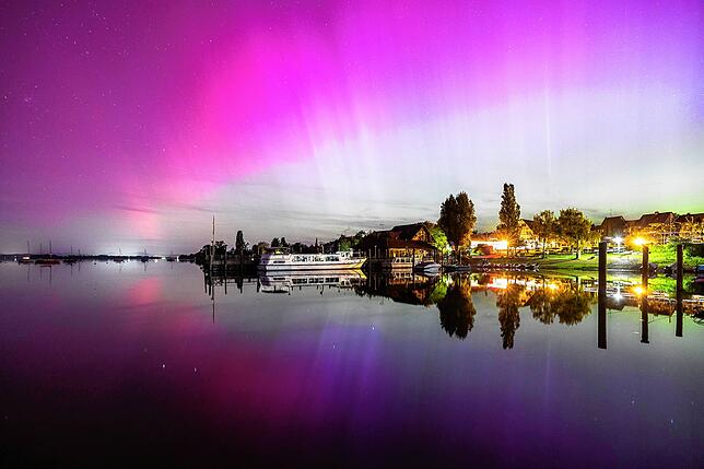 Im spiegelglatten Wasser ist das Polarlicht gleich noch einmal zu sehen.