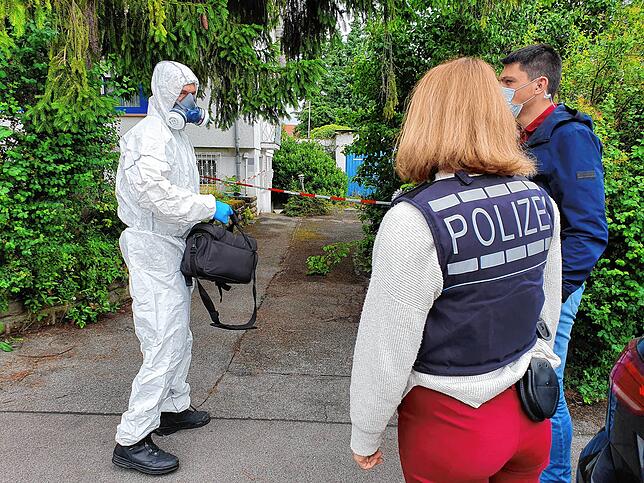 Ein Spurensicherer vor dem Tatort im Gespräch mit Kollegen der Kriminalpolizei Rottweil.