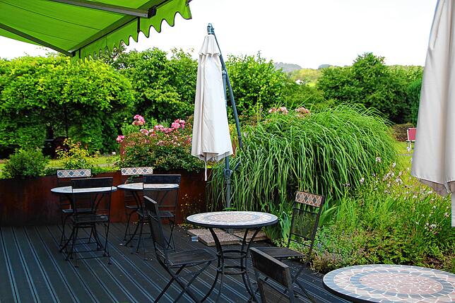 Auf der idyllischen Terrasse können die Gäste im Grünen speisen.