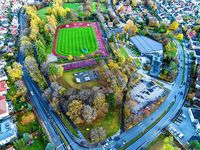 Blick auf das Gebiet Hubenloch: Rechts mit dem markanten Flachdach das Hallenbad, in der Mitte die Leichtathletikanlage des Turnvereins, ...