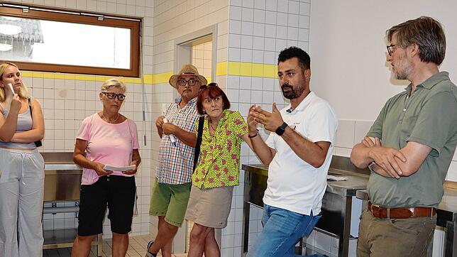 Ali Ekinci (zweiter von rechts) führt eine Gruppe durch die neue Gemeinschaftsunterkunft in Beuren. Hier zeigt er die Gemeinschaftsküche.