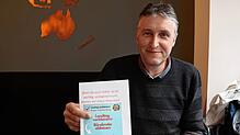 Michael Roth und der Flyer, mit dem er in der Nachbarschaft geworben hat.