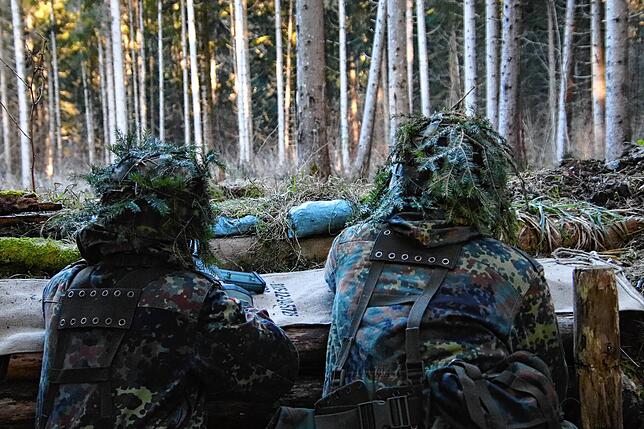 Wo taucht der Feind auf? Zwei Jäger beobachten den Waldabschnitt, in dem sich die Feinddarsteller versteckt halten.